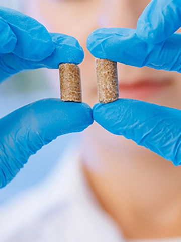 Woman worker control pellet combined feed for production food for animal in laboratory.