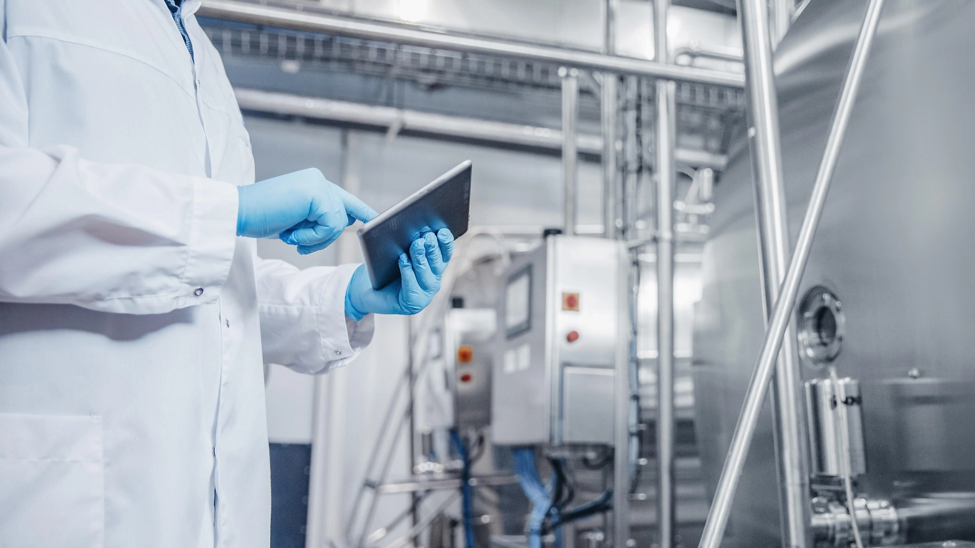 Concept control food industry banner. Factory worker inspecting production line tanker in of dairy with computer tablet.