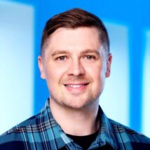 Man in plaid shirt with blue backdrop