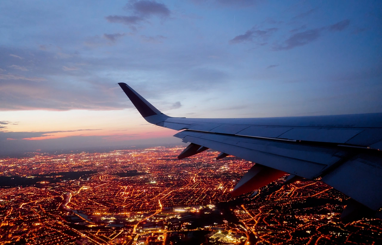 Wing of modern aircraft flying above Paris at night