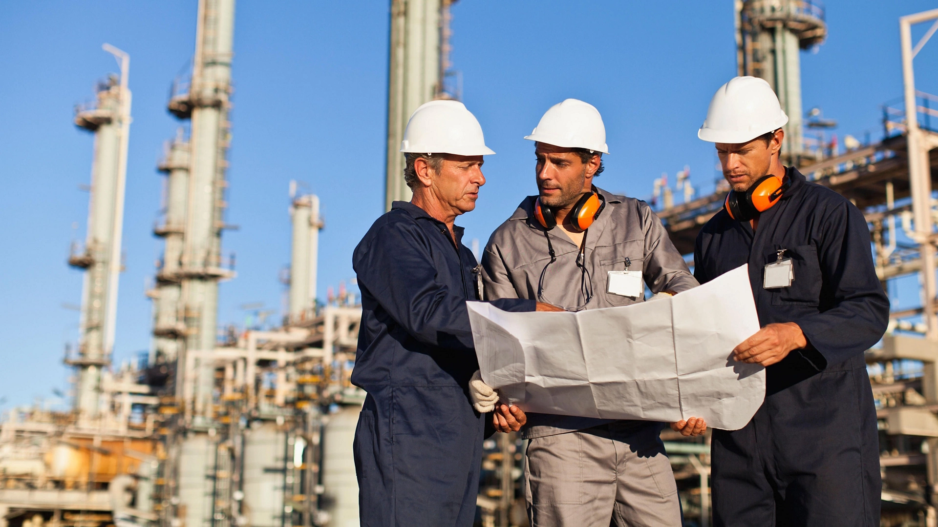 CRJ758 Workers with blueprints at oil refinery